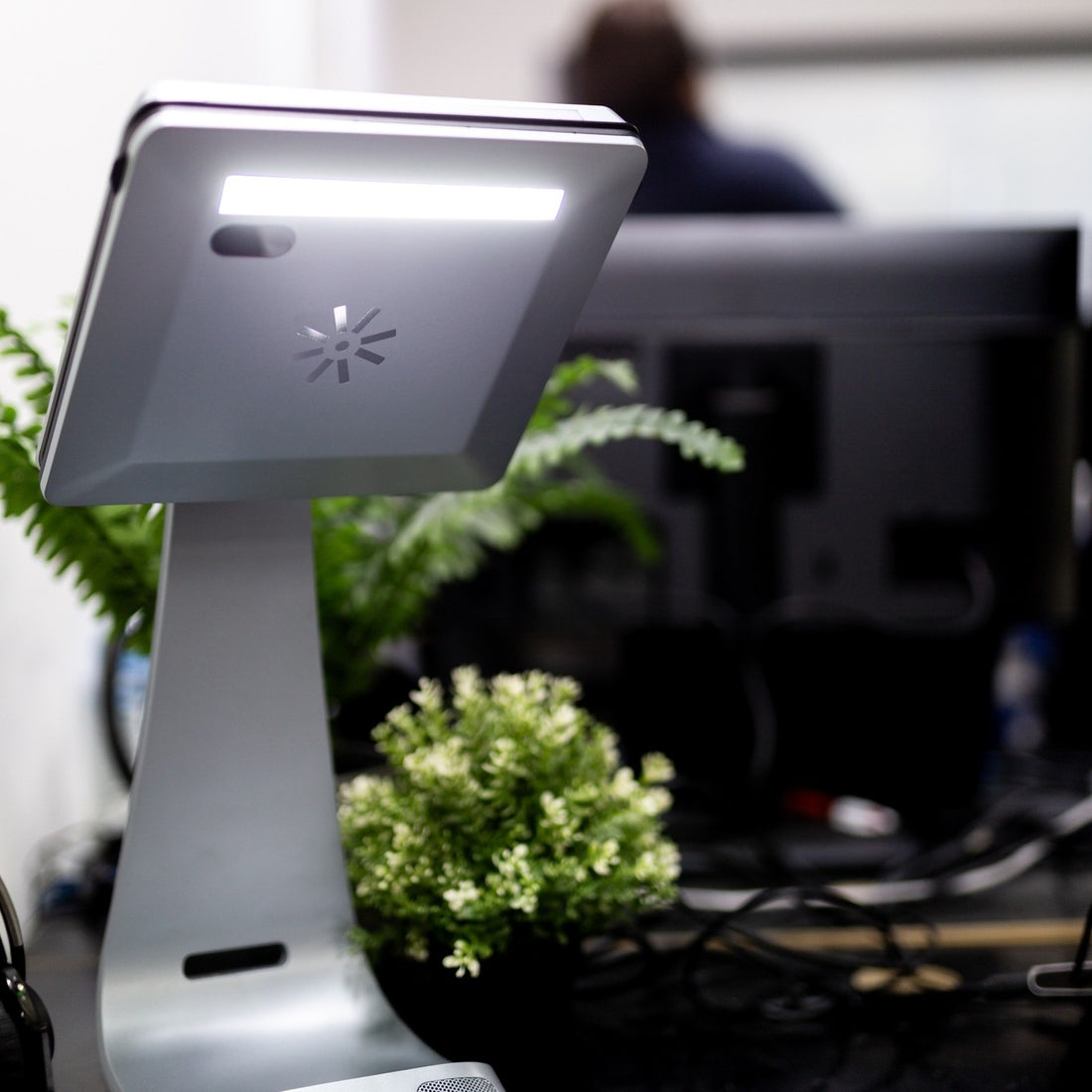 iVi beside a laptop for scale, showing its size in a workstation setup.